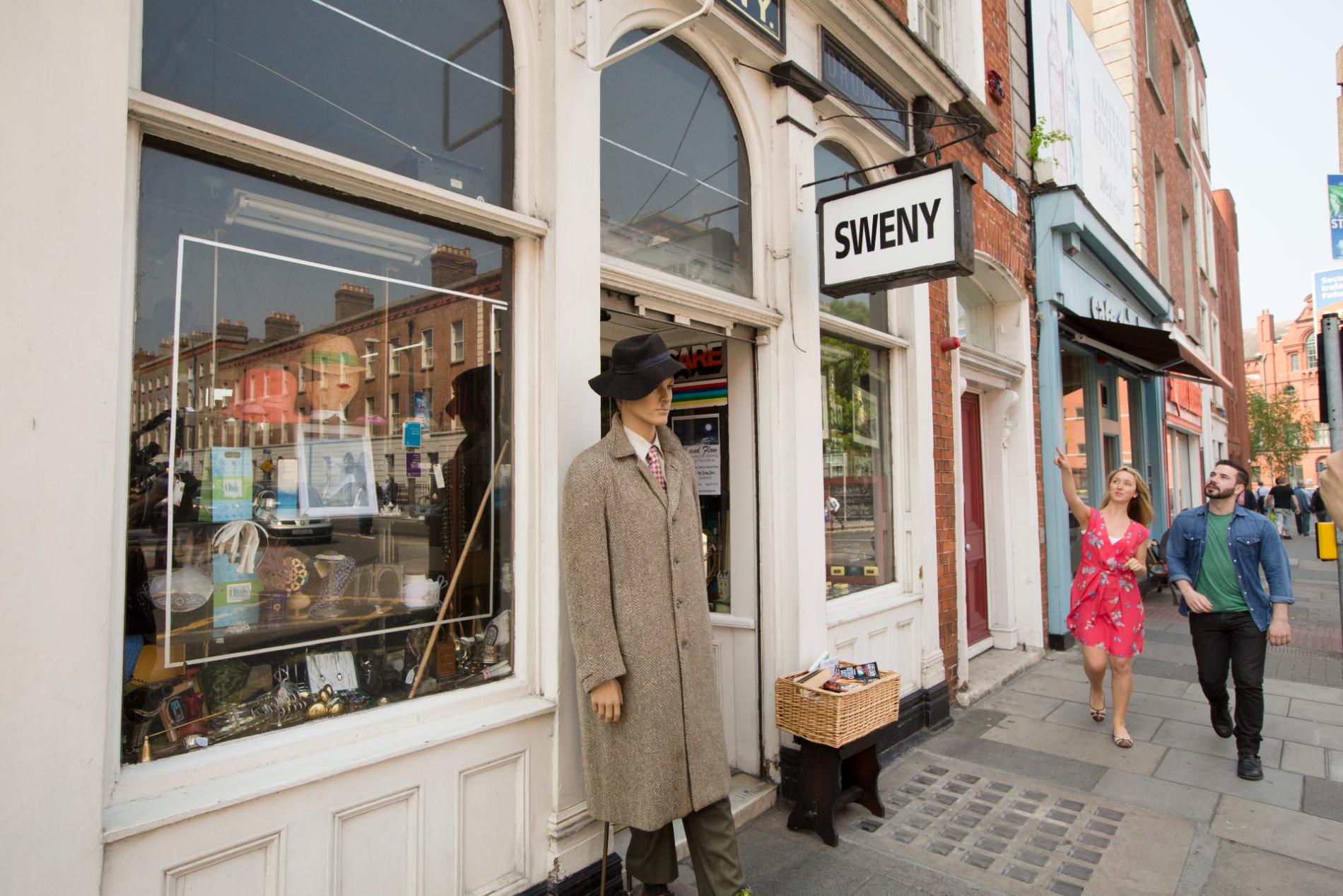 Sweny’s pharmacy exterior in Dublin with mannequin and visitors on Bloomsday.