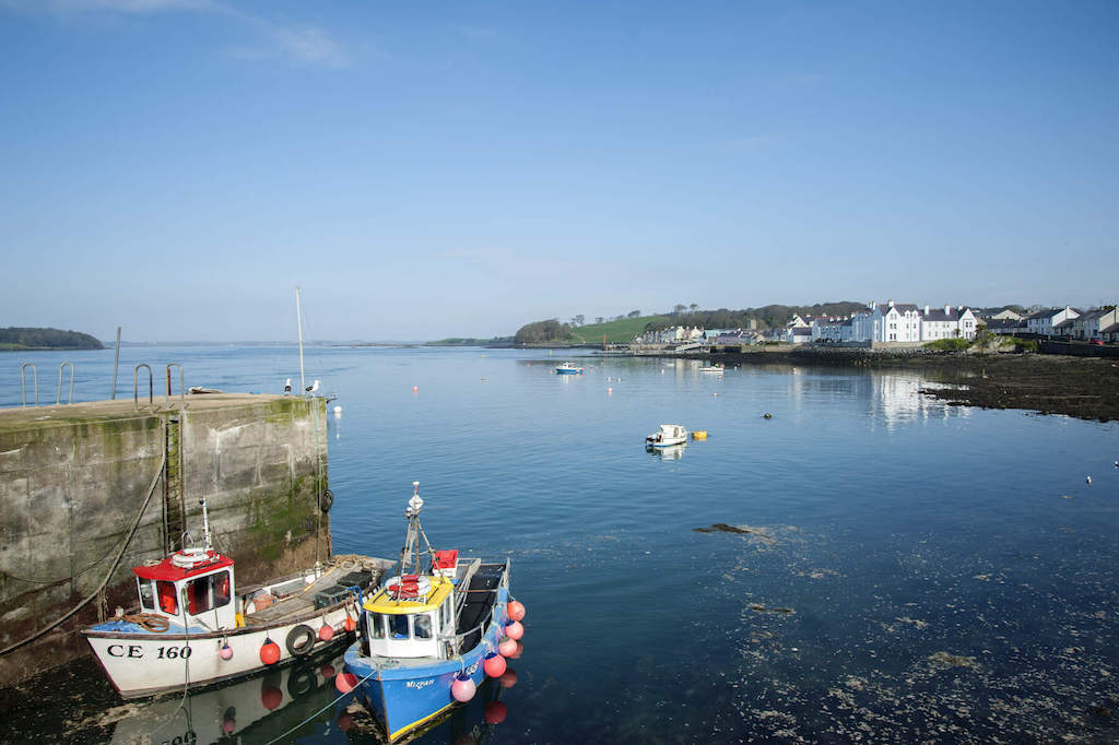 Fishing boats moored at Strangford Harbour in County Down on a calm, sunny morning.