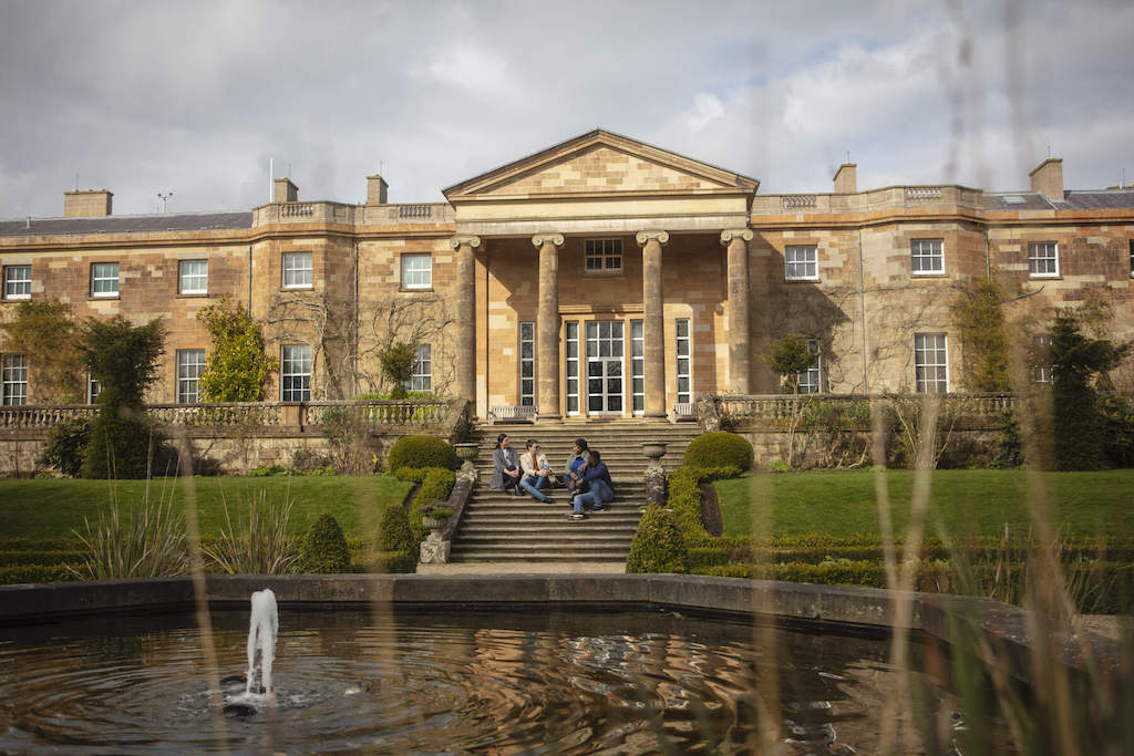 Hillsborough Castle and Gardens in County Down, with visitors sitting on the steps by the fountain.