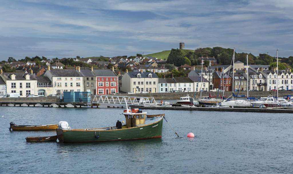 Harbourfront of Portaferry, County Down, with colourful houses and fishing boats in the water.