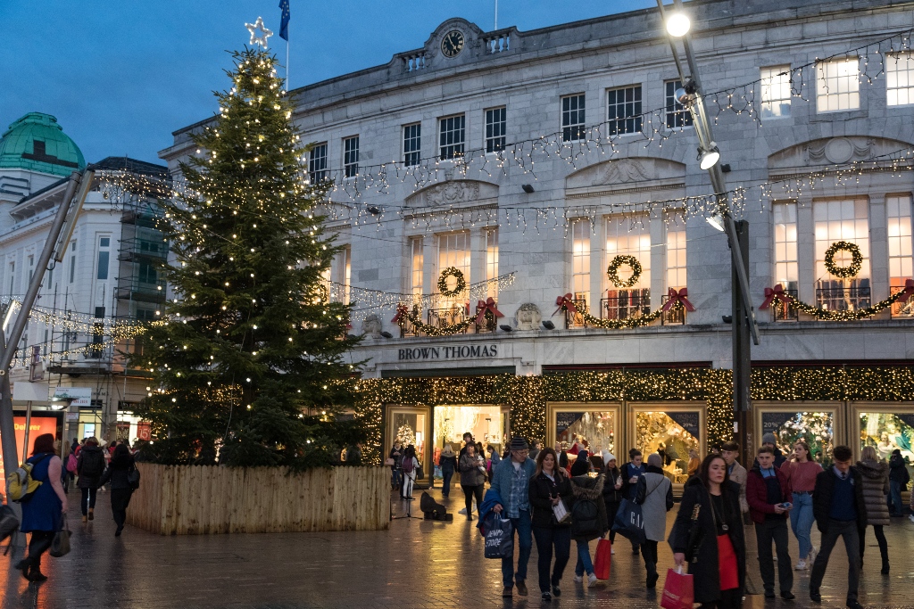 Christmas tree and festive lights on busy city streets in Cork city.