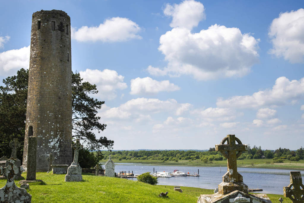 Ancient round tower and Celtic crosses at Clonmacnoise monastery overlooking the River Shannon.