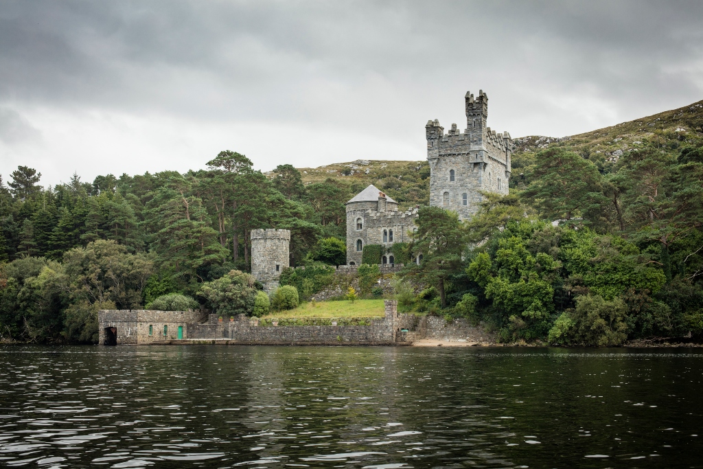Glenveagh Castle on the shores of Lough Veagh surrounded by forest in Glenveagh National Park.