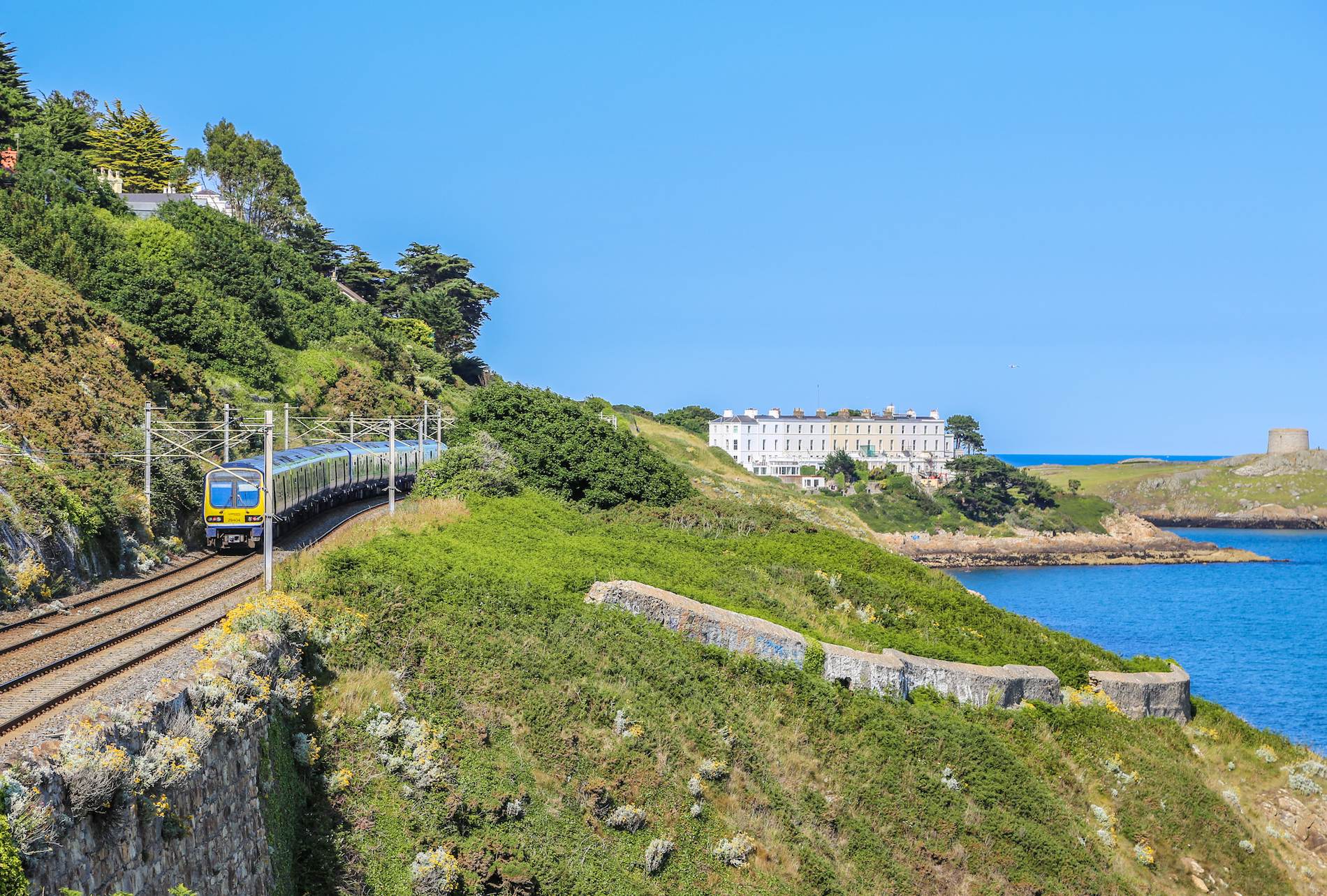 DART train travels along a coastal rail line near Dublin, promoting public transport travel across Ireland.