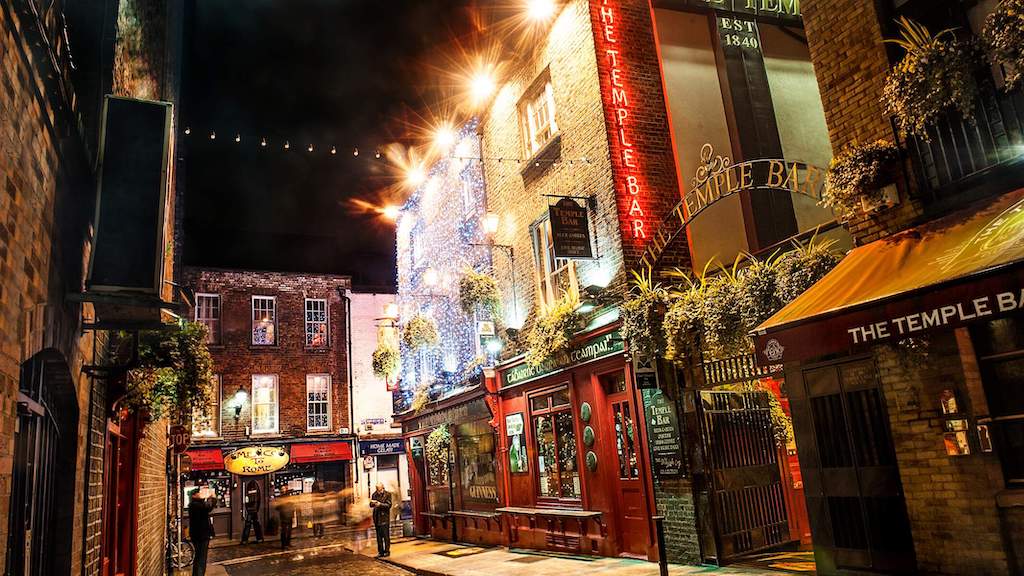 Temple Bar in Dublin lit with festive Christmas lights and bustling nightlife.