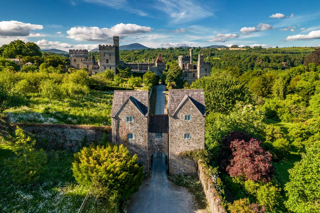 Aerial view of Lismore Castle surrounded by trees and walled gardens.