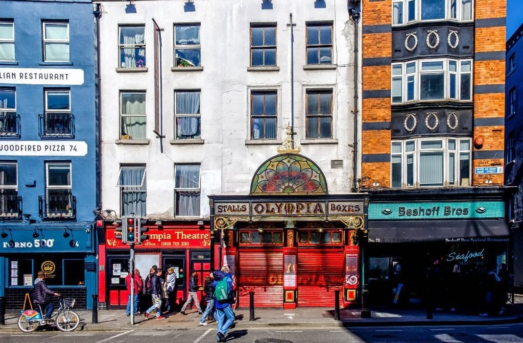 The historic Olympia Theatre in Dublin city centre, with its ornate façade beside restaurants and shops.