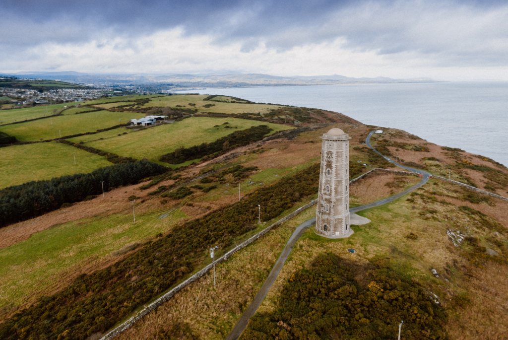 Wicklow Head Lighthouse overlooking coastal farmland and sea cliffs in County Wicklow.