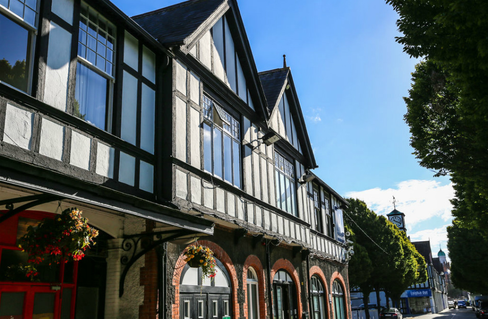 Black and white Tudor-style building with large windows in a sunny street in Dublin.