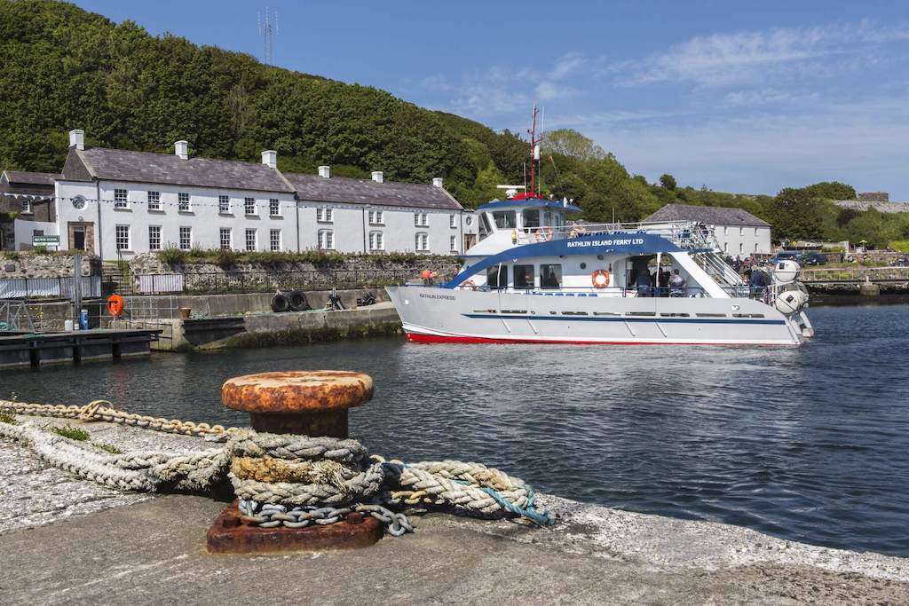 Rathlin Island ferry arriving at the harbour in County Antrim, with white cottages along the shore.