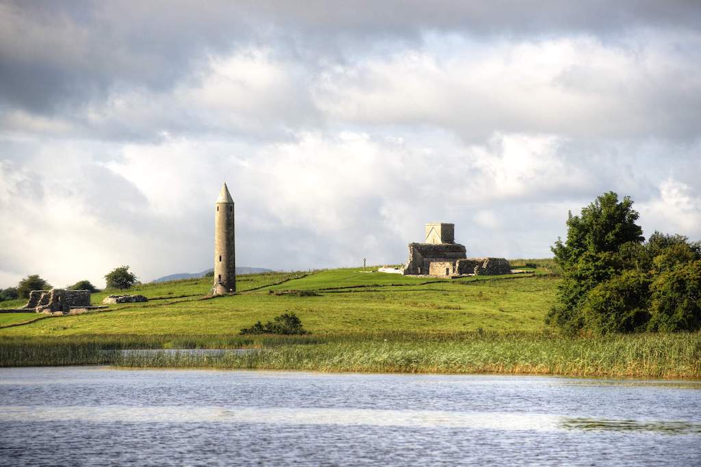 Round tower and monastery ruins on Devenish Island, Lough Erne, County Fermanagh, seen from the water.