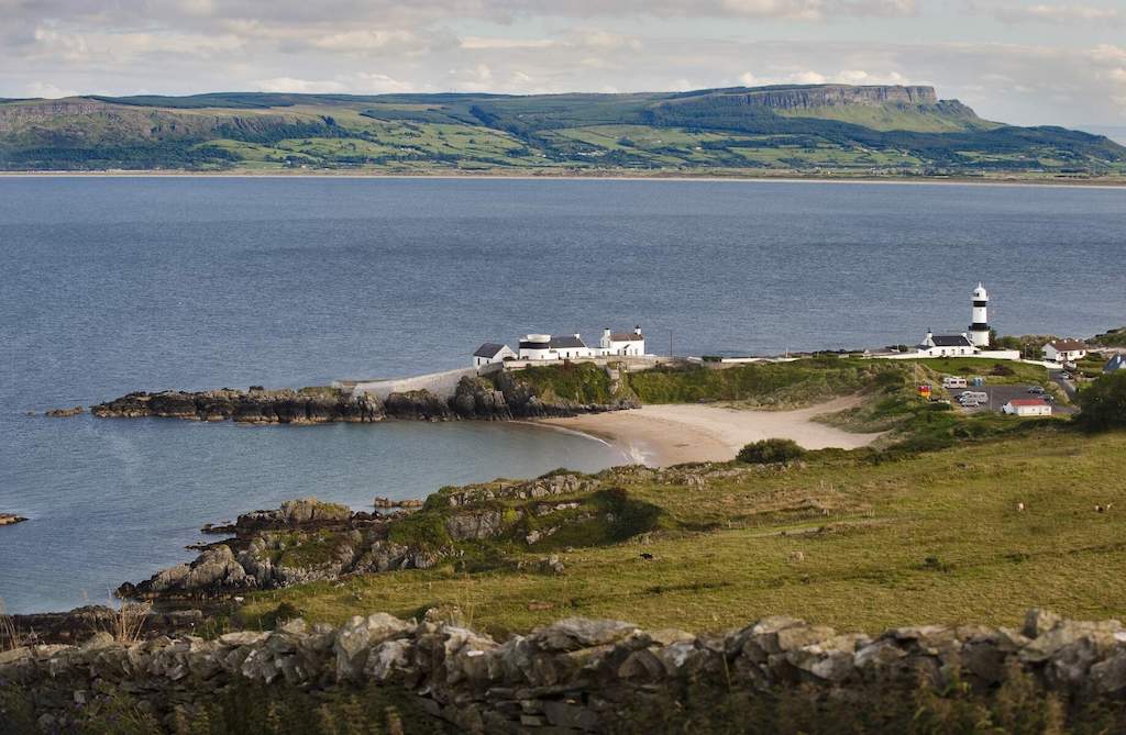View of Stroove Lighthouse near Greencastle, County Donegal, with beach and cliffs across Lough Foyle.