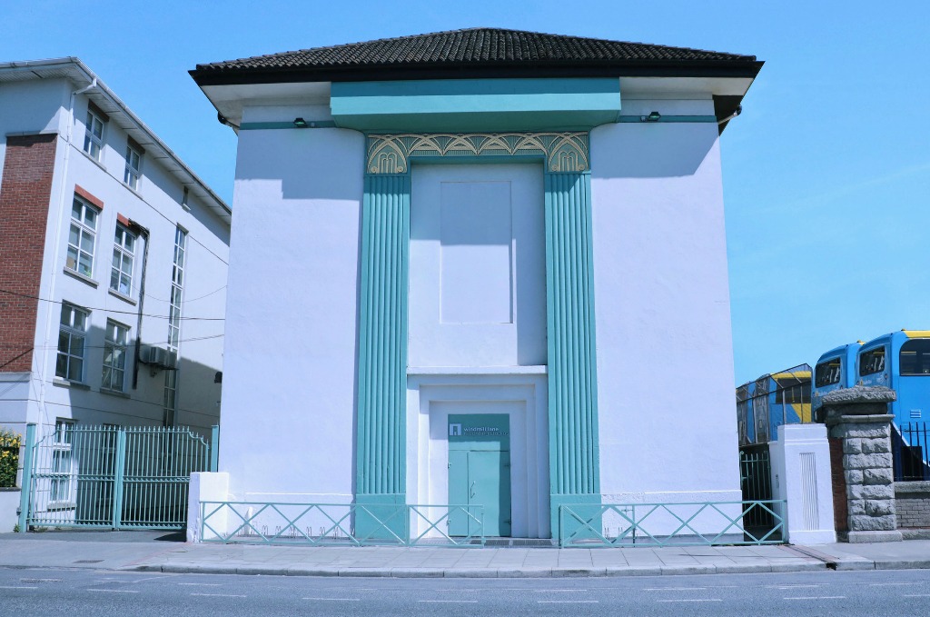 White Art Deco facade of Windmill Lane Studios, with turquoise trim and clear blue sky in Dublin.