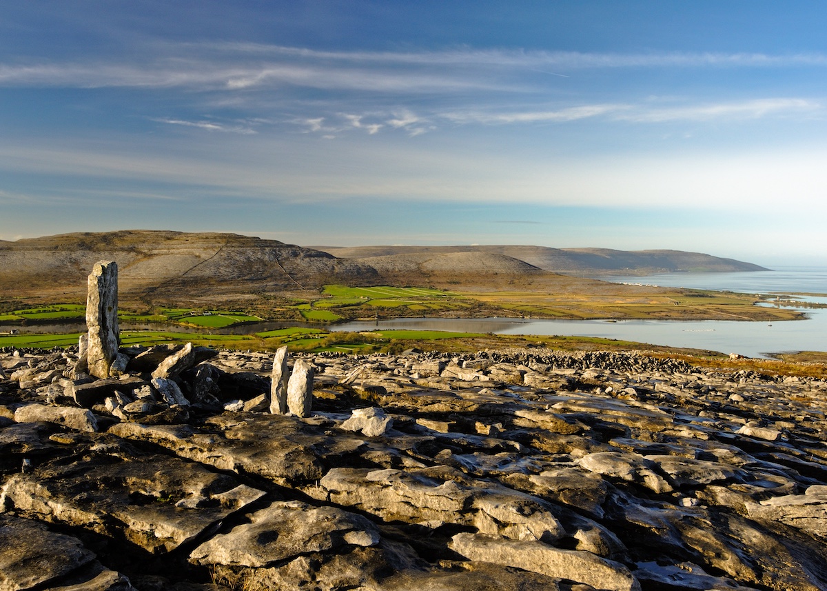 Limestone flagstones and standing stones overlook Galway Bay from Abbey Hill in County Clare.