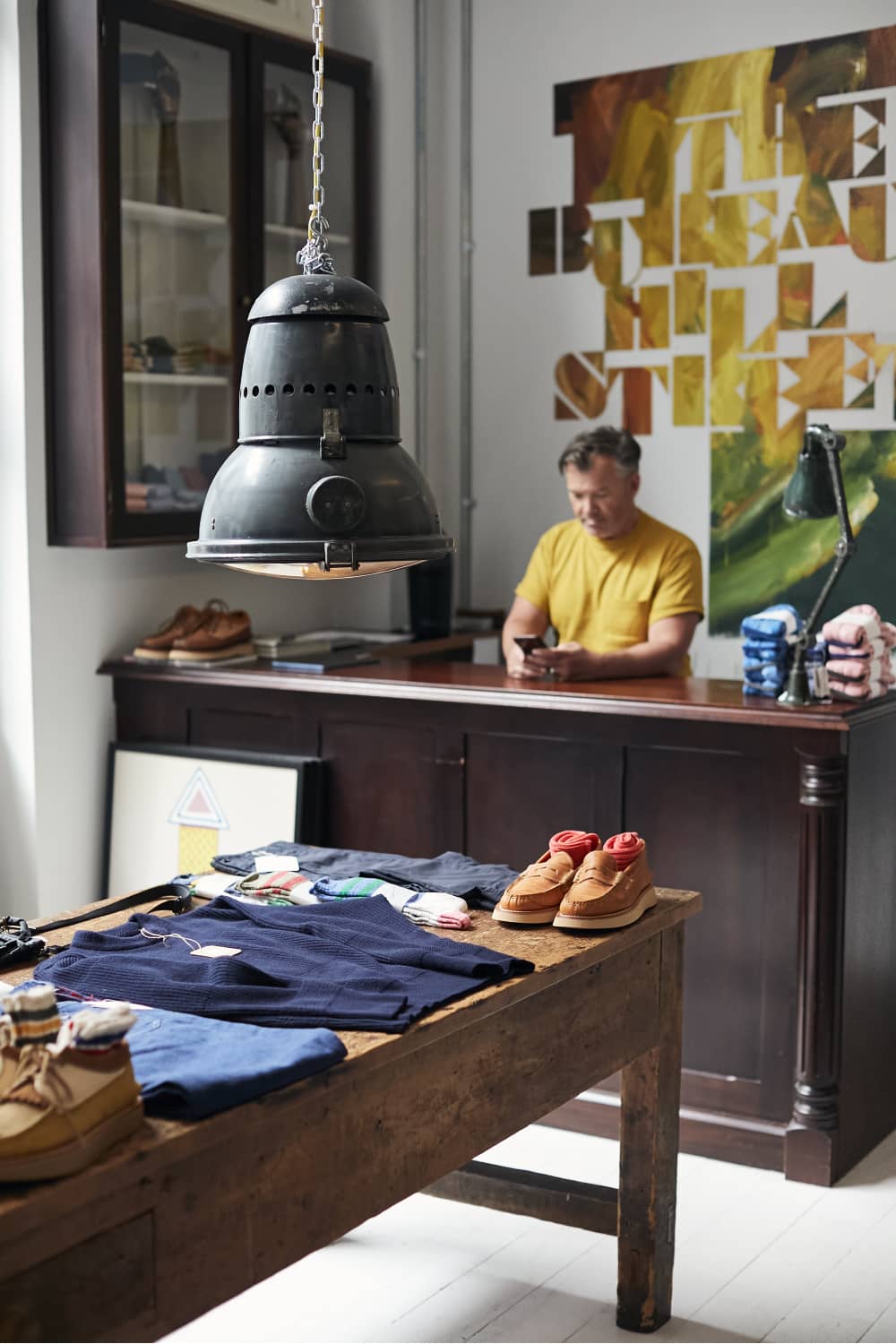 Inside The Bureau boutique, Belfast, with clothing and shoes displayed on a wooden table.