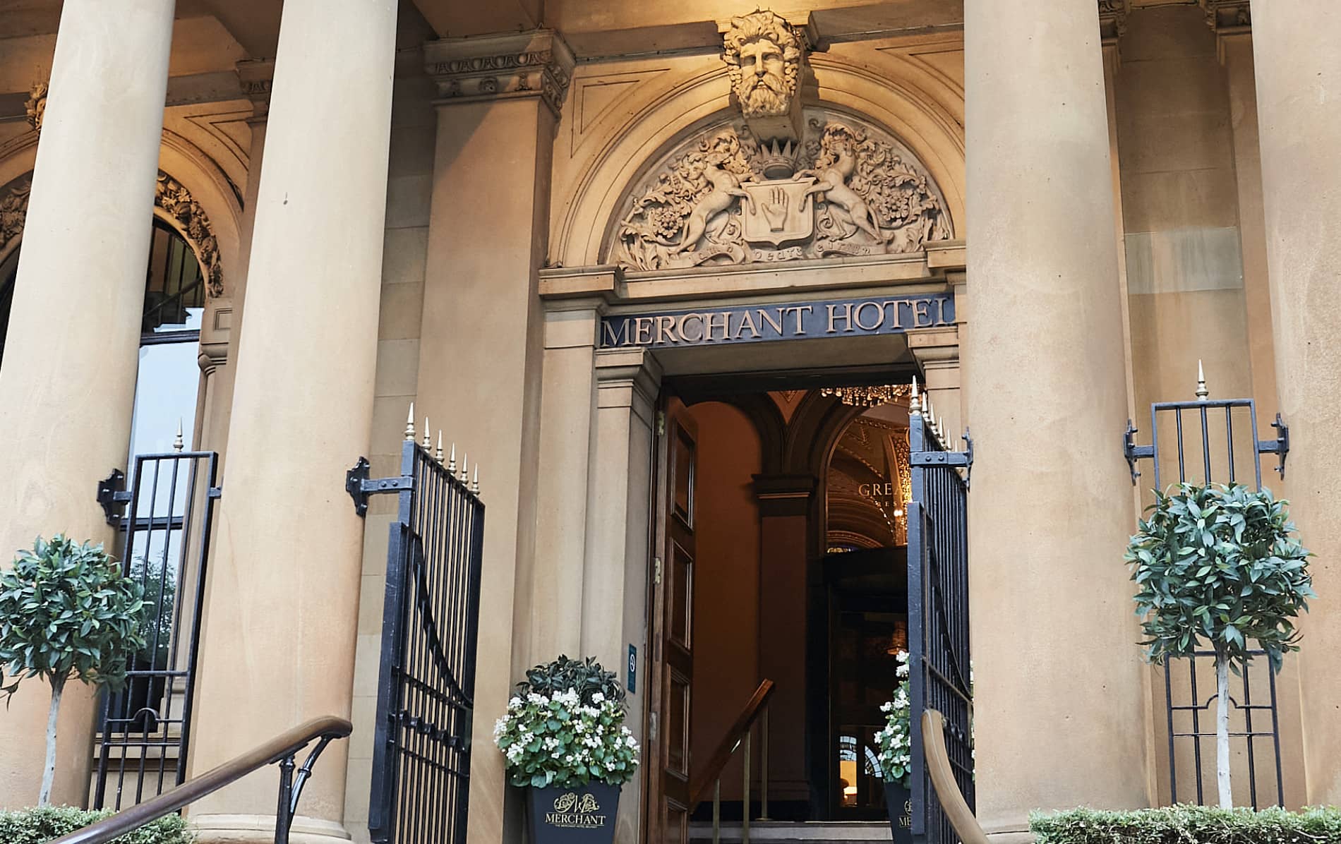Entrance to The Merchant Hotel, Belfast, with ornate stone carvings and tall columns.