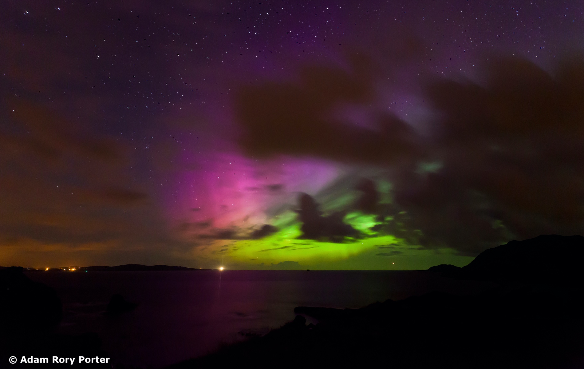 The Northern Lights in green and purple hues illuminate the night sky above Fort Dunree in County Donegal.