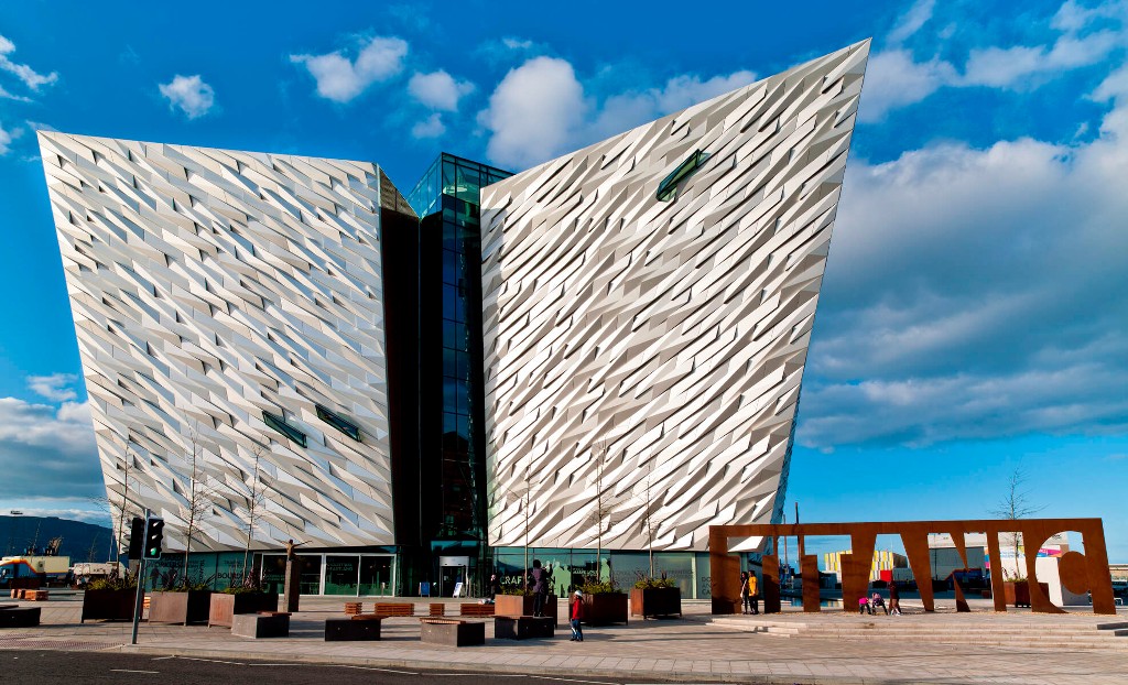 Titanic Belfast museum with striking ship-shaped facade and large ‘TITANIC’ sign outside.