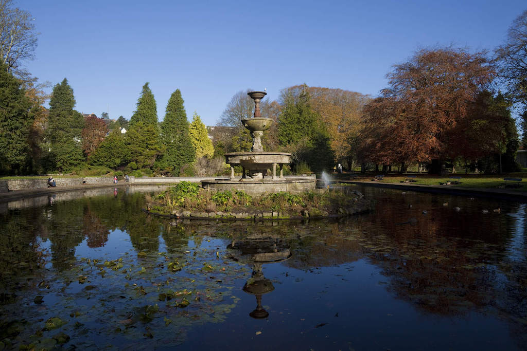 Ornamental fountain and pond surrounded by trees in Fitzgerald Park, Cork.