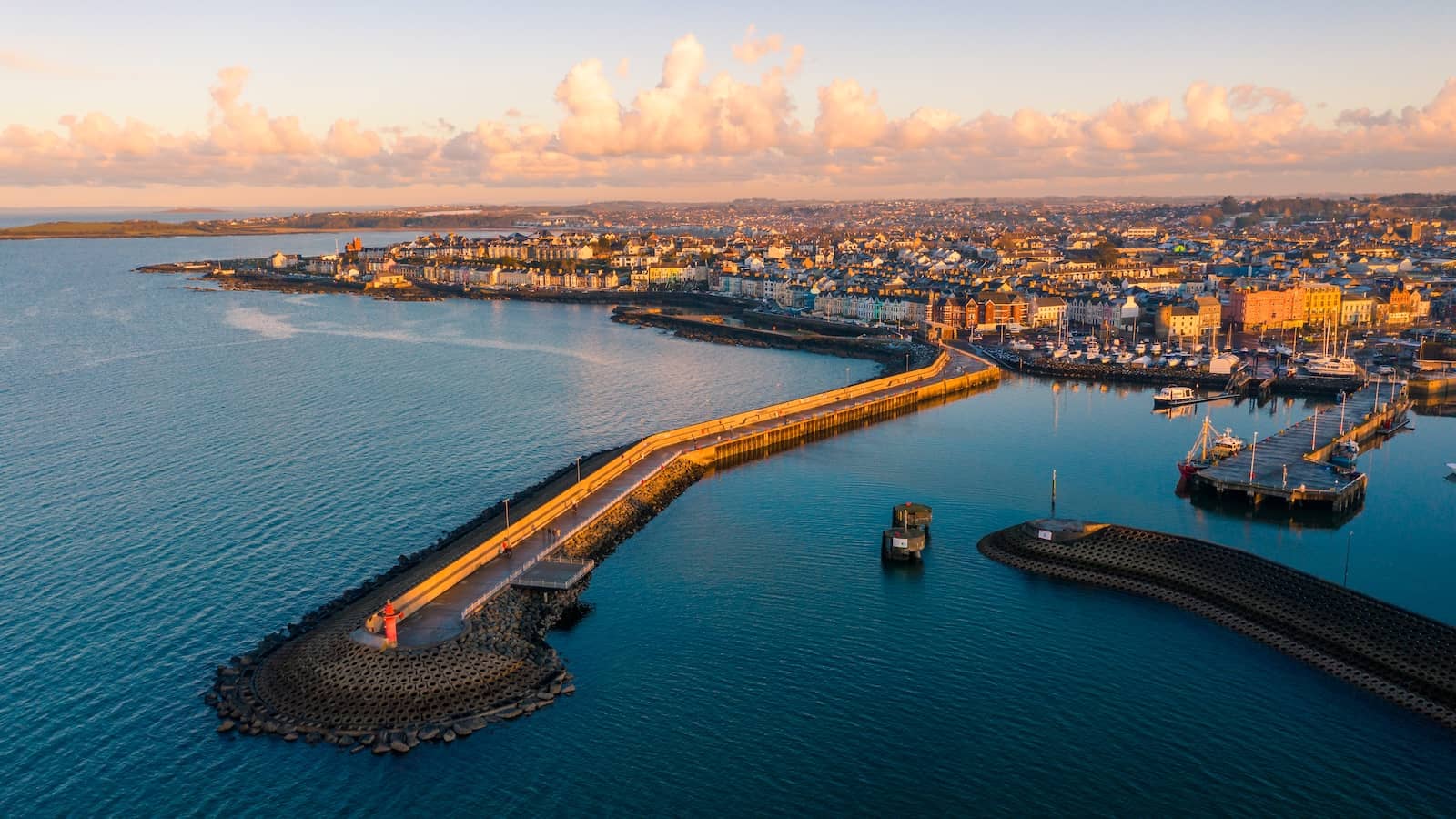 Aerial view of Bangor Harbour in County Down with marina, seafront promenade and calm coastal waters at sunset.