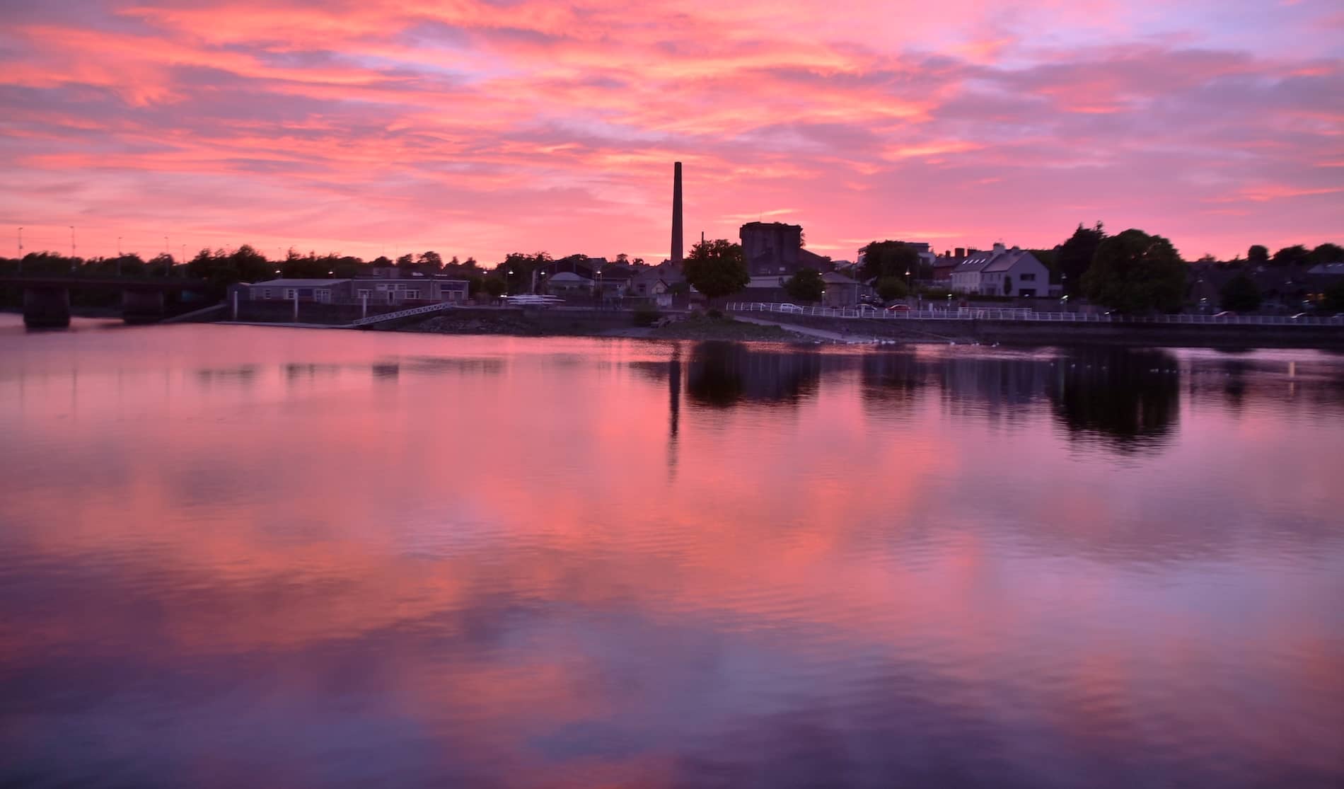 Sunset over the River Shannon at O’Callaghan Strand in Limerick City, reflected in calm water.