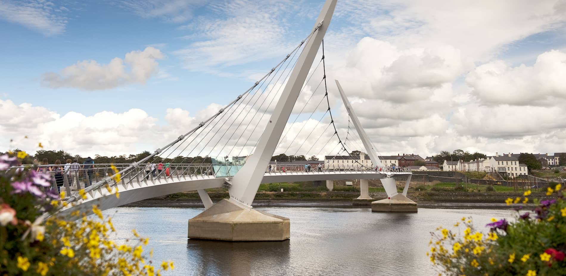 People crossing the Peace Bridge over the River Foyle in Derry city.