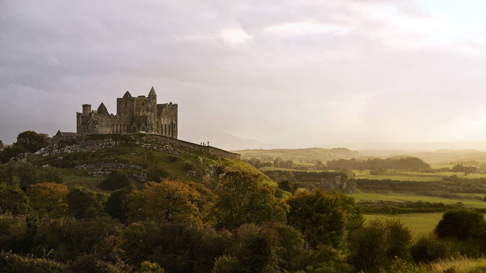 Rock of Cashel rising above the Tipperary countryside under soft evening light.