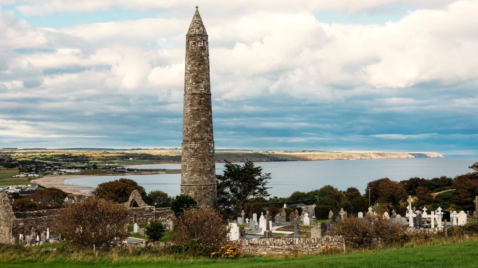 Ardmore Round Tower in County Waterford, rising above an old graveyard with sweeping views of the coastline.