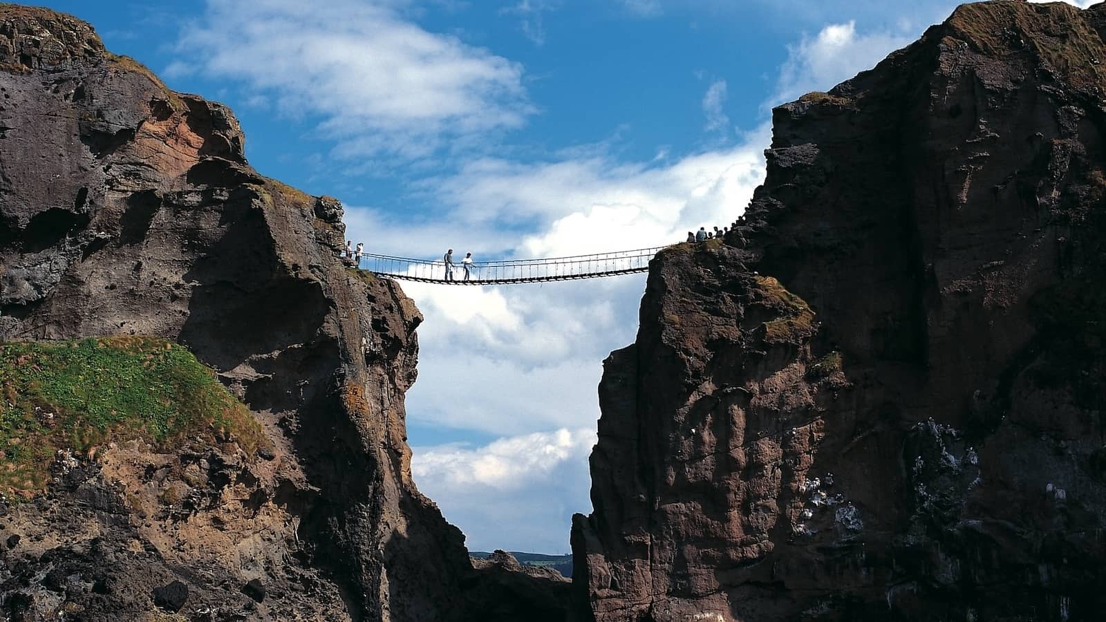 Carrick-a-Rede rope bridge suspended between cliffs above the sea on the County Antrim coast.