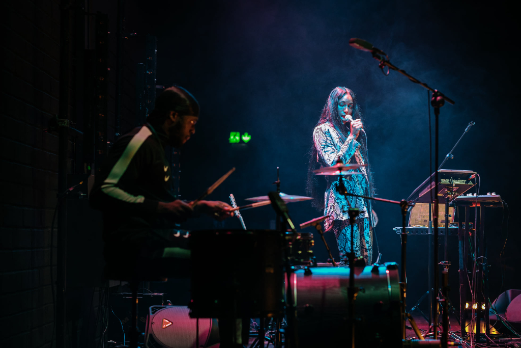 Singer and drummer performing on stage at the Dublin Fringe Festival.