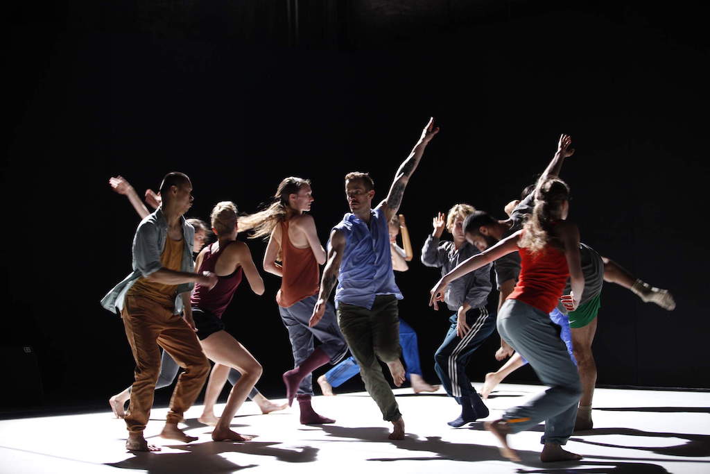 Contemporary dance group performing on stage under dramatic lighting in Dublin.
