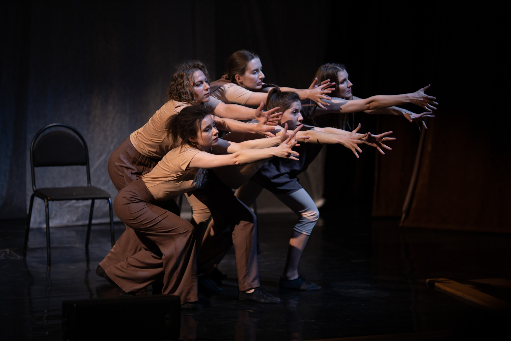 Contemporary dance performers reaching forward on stage during a Dublin theatre show.