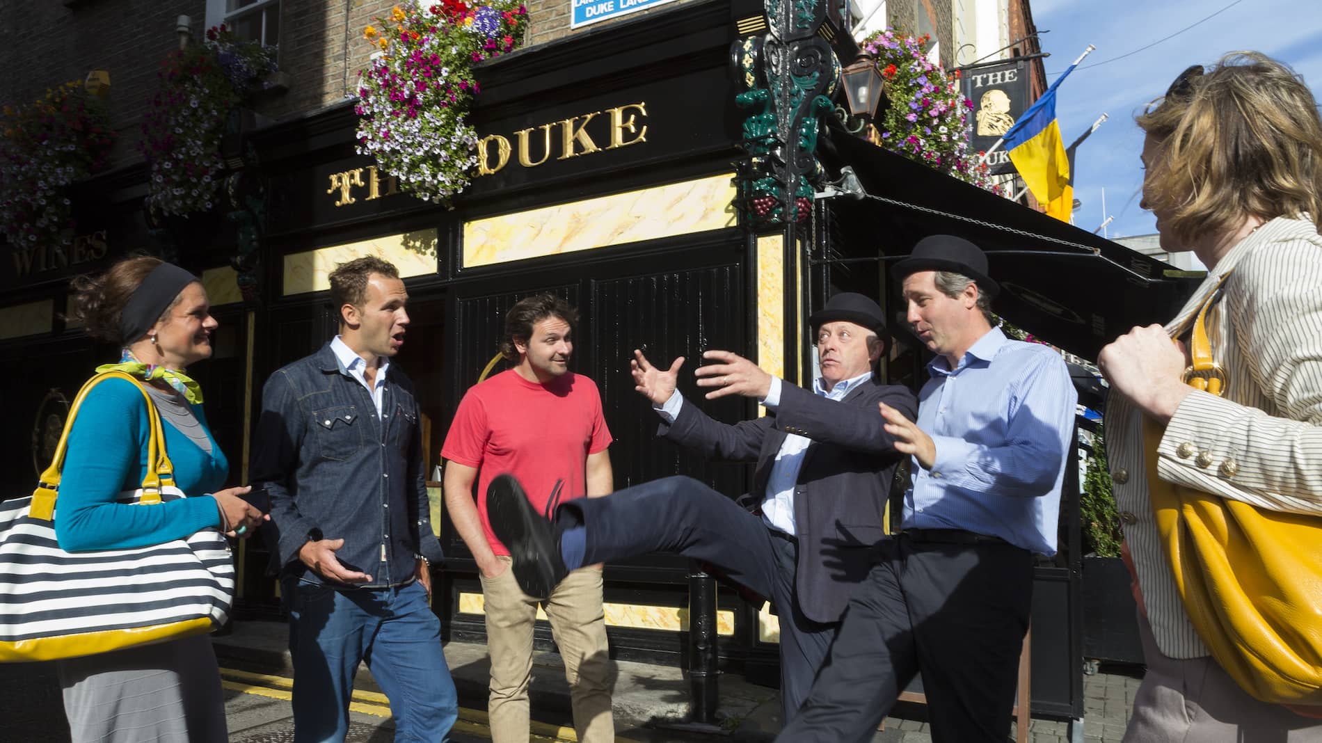 Street performers entertain a group outside The Duke pub in Dublin on a literary walking tour.