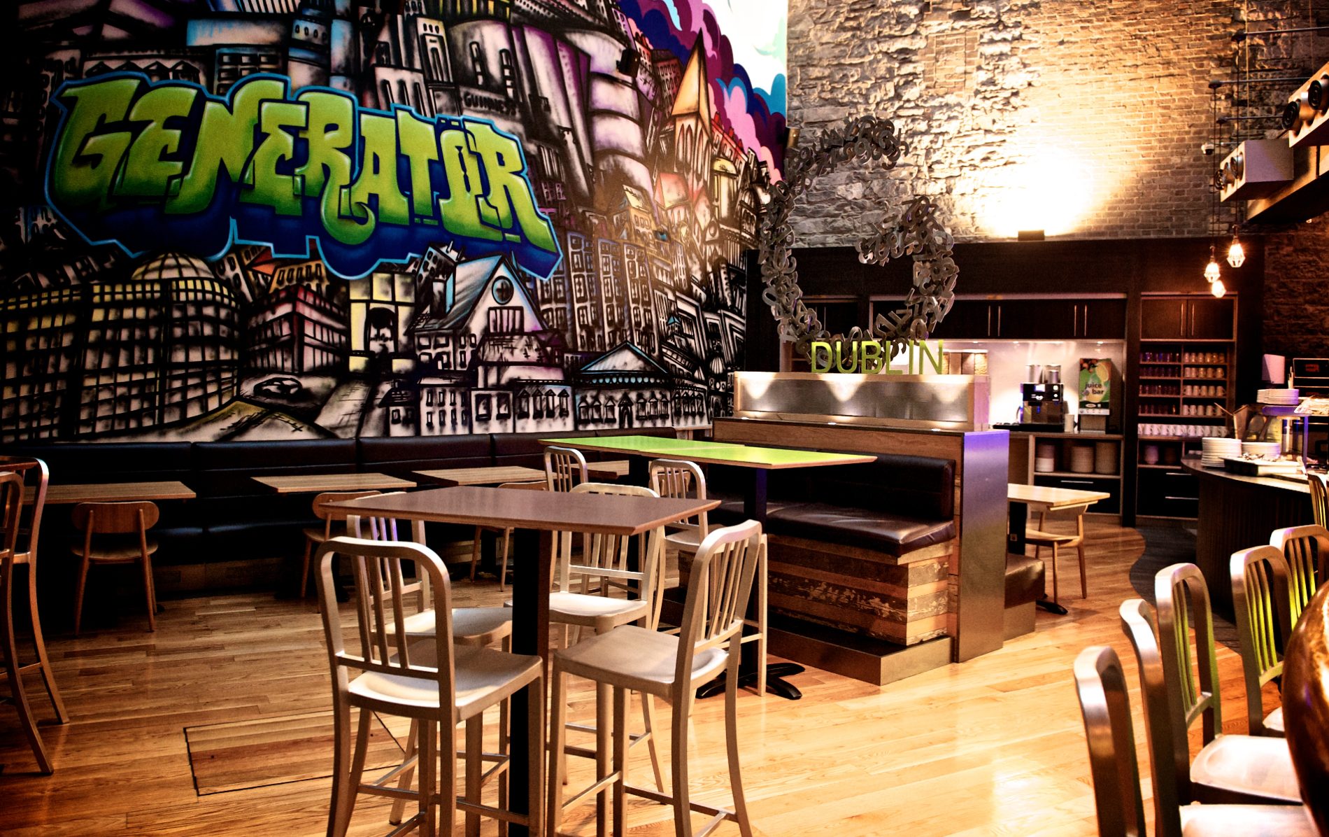 Colourful graffiti mural inside Generator Hostel Dublin with tables and chairs in the dining area.