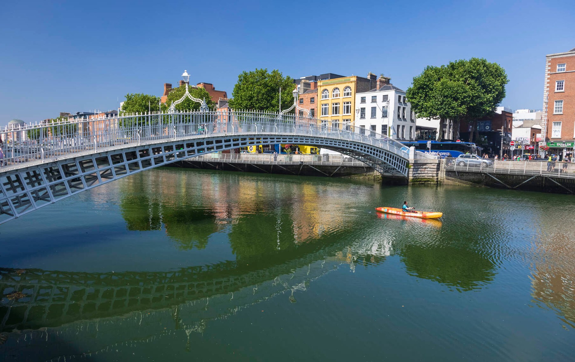 Kayaker paddling under the Ha’penny Bridge on the River Liffey in Dublin city centre.