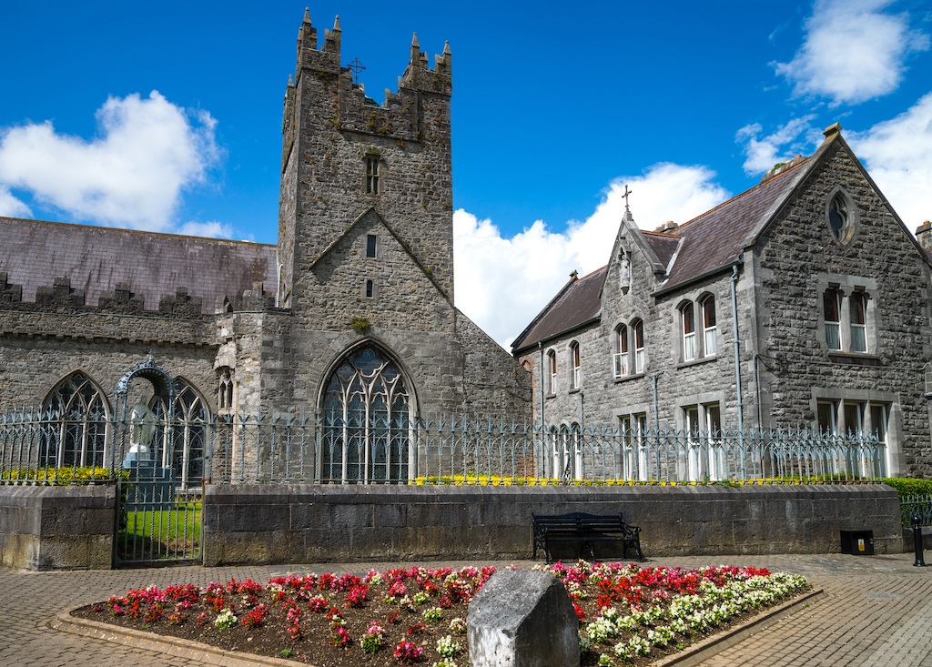The Black Abbey in Kilkenny, a medieval stone church with tower, gothic windows and gardens.