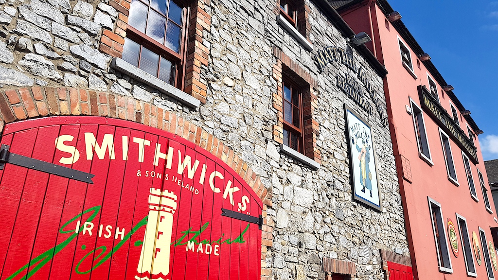 Smithwick’s Experience Kilkenny with red gate and stone walls beside Matt the Millers bar.