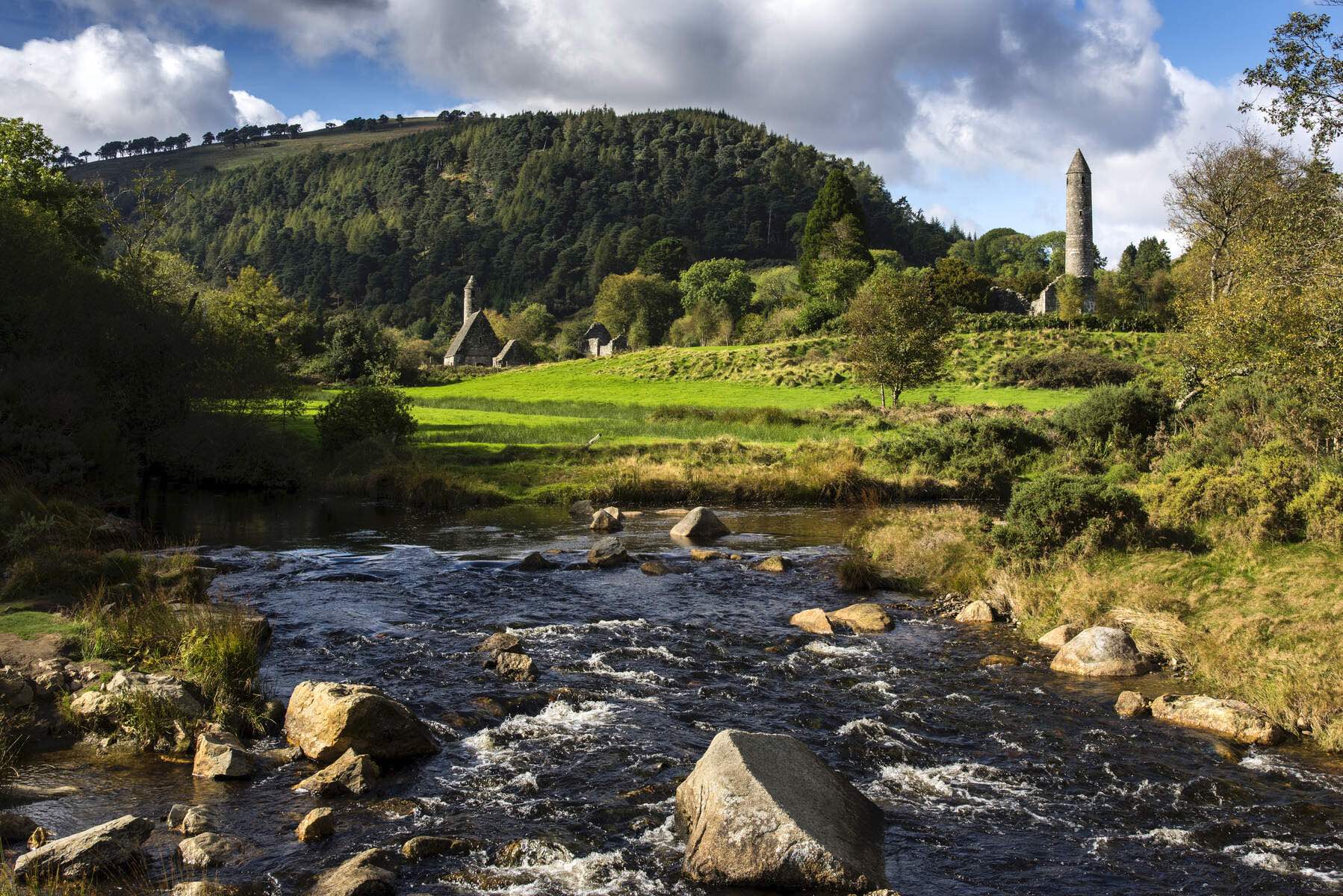 Ancient round tower and stone church at Glendalough Monastic City in County Wicklow, Ireland.