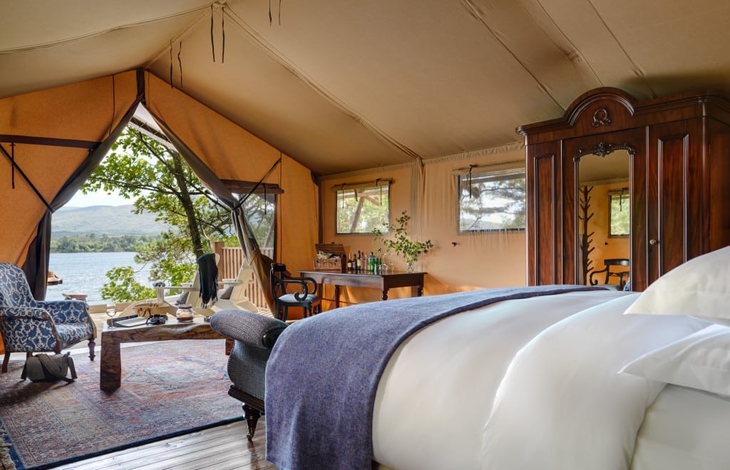 A luxury safari tent at Dromquinna Manor, County Kerry, with antique furniture and views of Kenmare Bay.