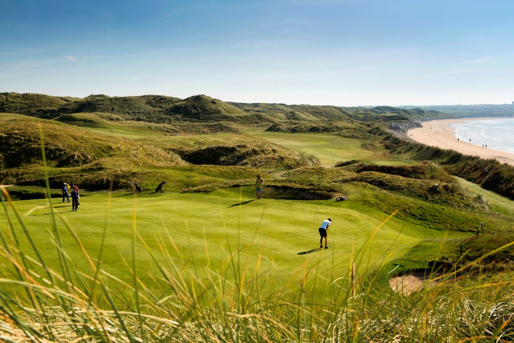Ballybunion Golf Club, County Kerry, with golfers playing beside sandy beach and dunes.