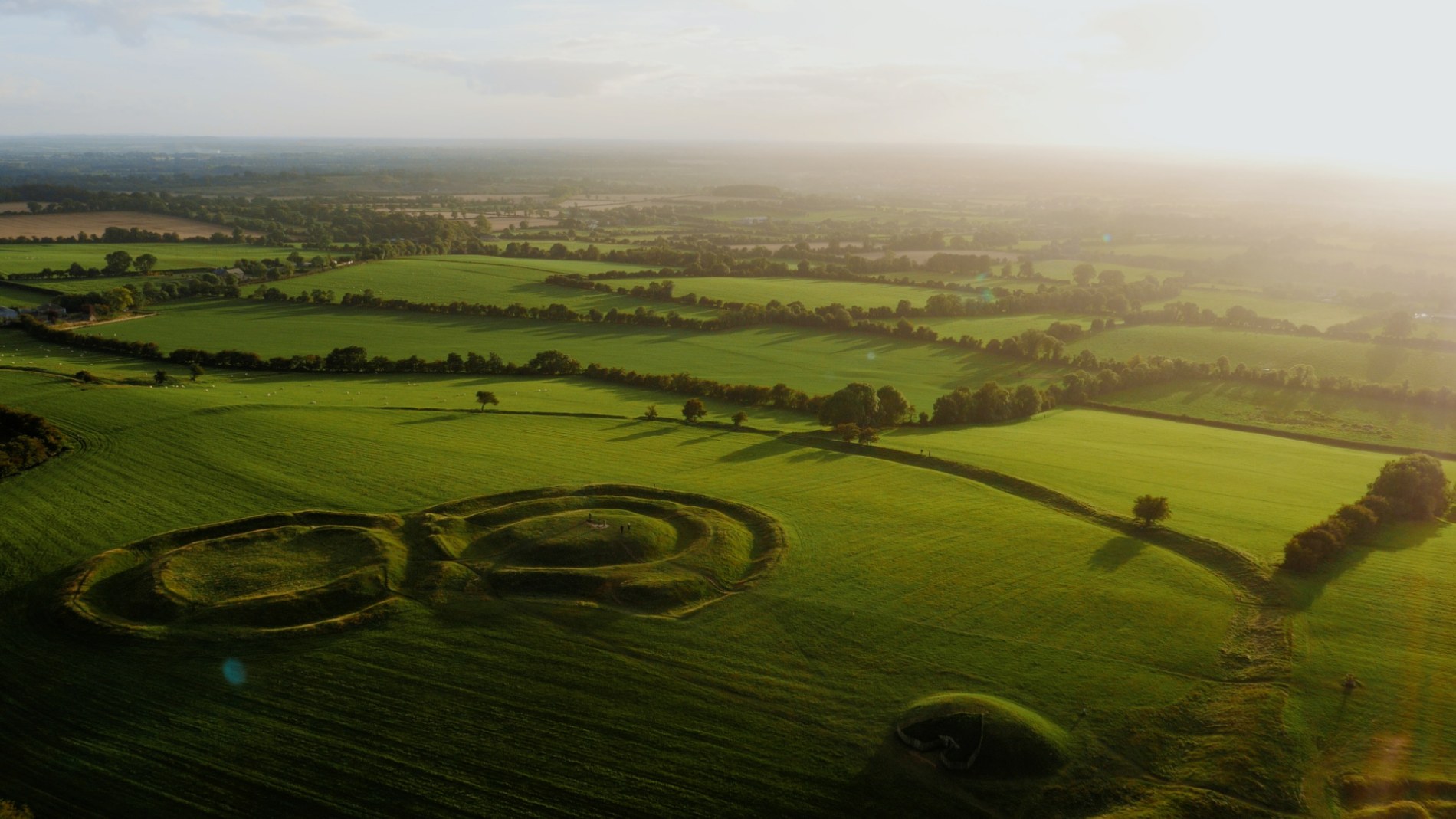 Early morning light over Rath of the Synods at the Hill of Tara, casting long shadows on the green fields of Meath.