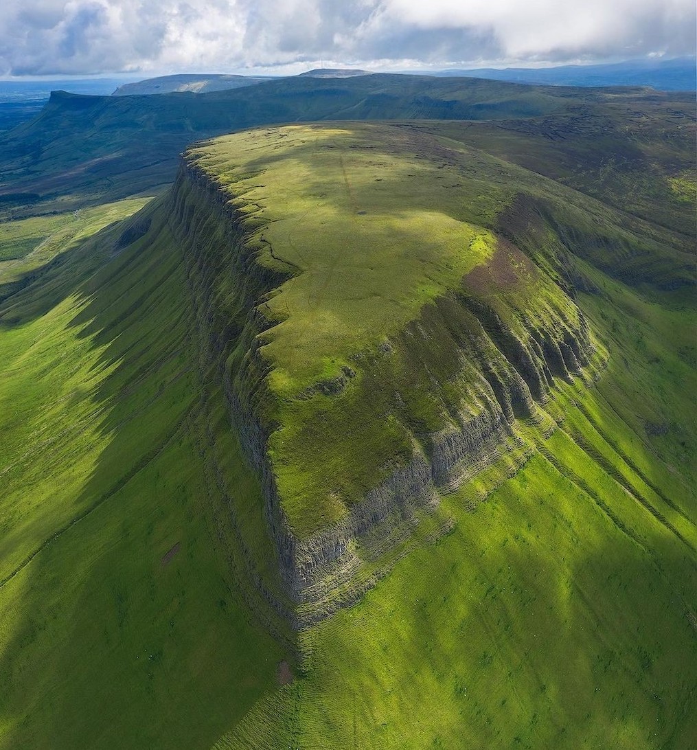 Aerial view of Ben Bulben’s flat-topped peak in County Sligo, its dramatic limestone cliffs surrounded by rolling green hills.