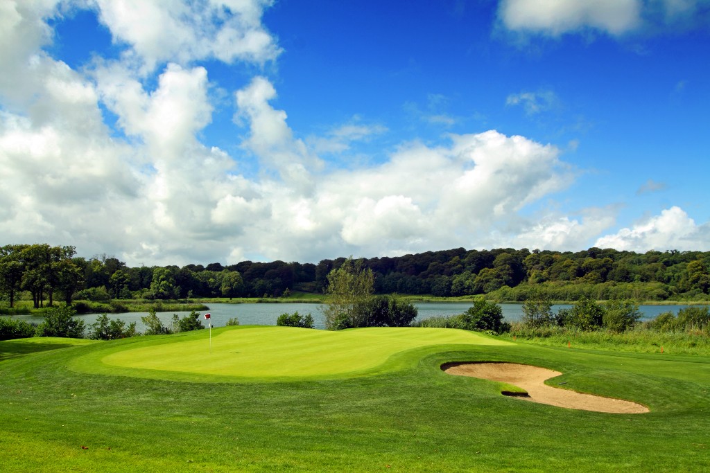 Golf green and sand bunker beside a lake, representing golfer Darren Clarke.