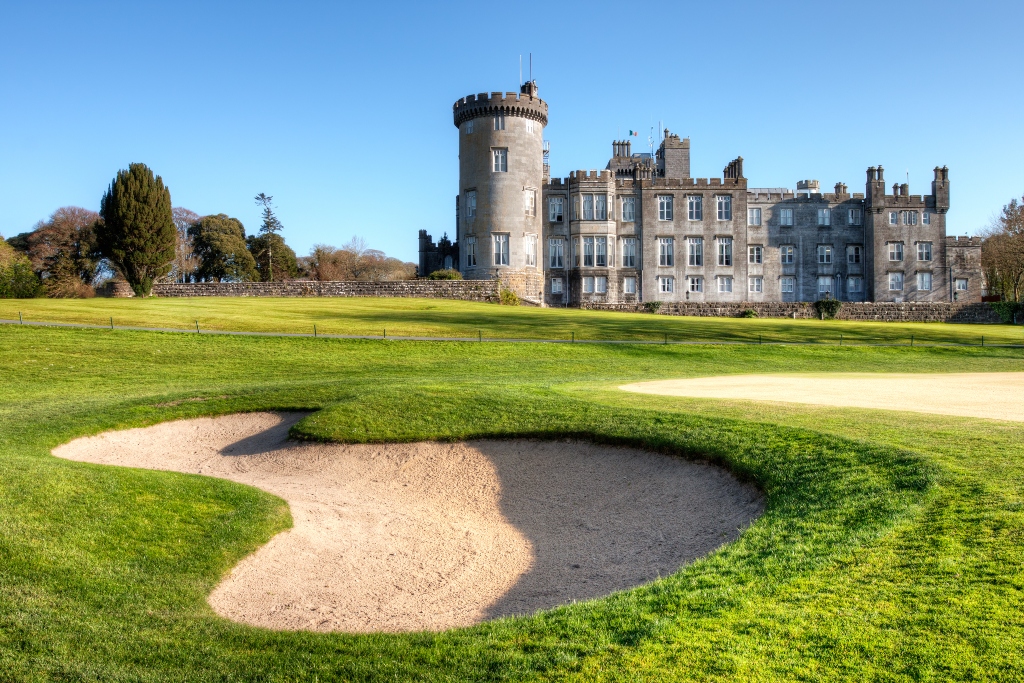 Sand bunker in front of a castle-like clubhouse, used for golfing queries or calls to action.
