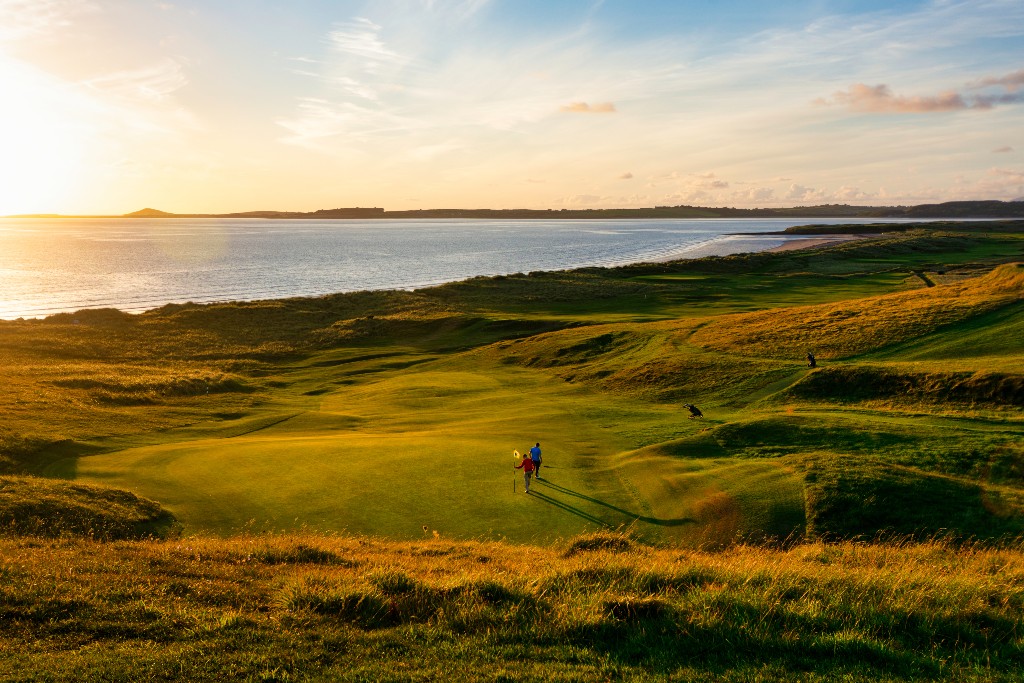 Golfer on a coastal links green at sunset with sea views, representing Graeme McDowell.