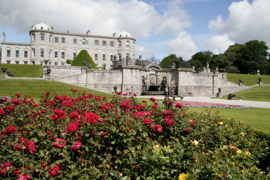 Grand mansion with formal rose garden and landscaped estate grounds.