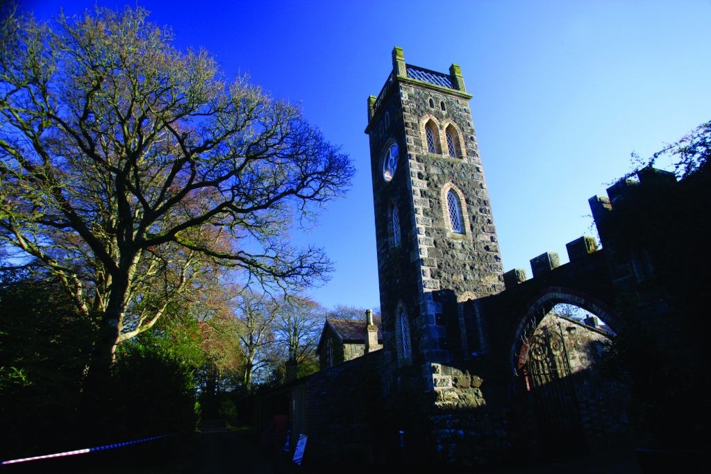 Tower gatehouse of historic garden estate under clear blue winter skies.