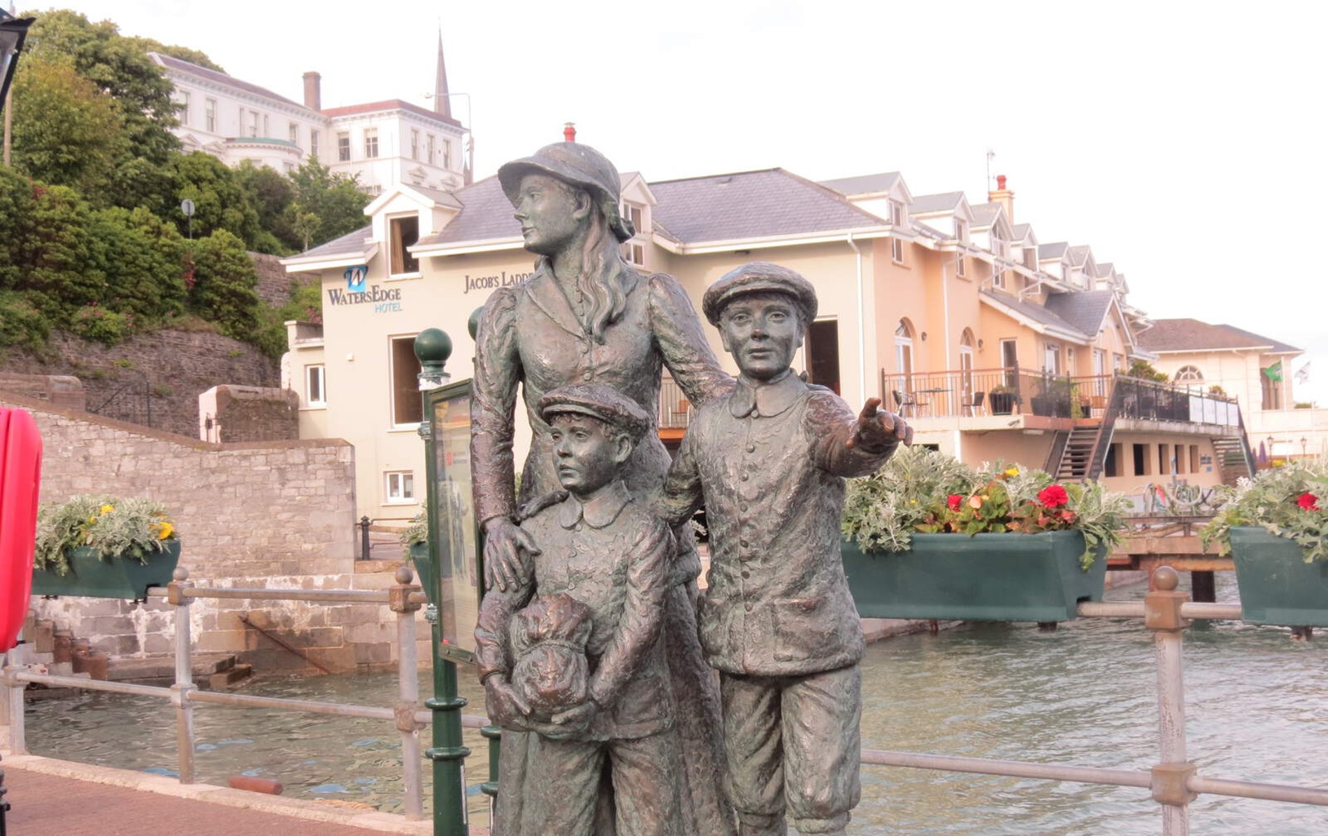 Bronze statue of Annie Moore and her brothers at Cobh harbour, symbolising Irish emigration history.