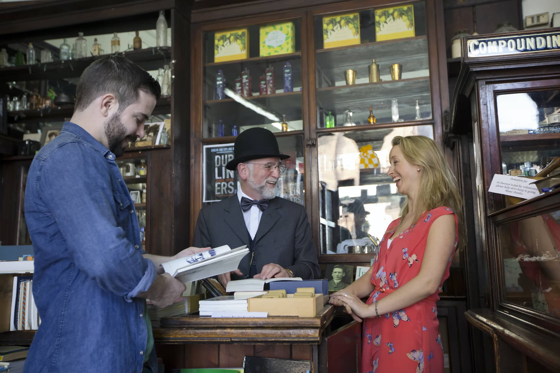 Visitors inside Sweny’s Pharmacy, Dublin, engaging with a James Joyce interpreter in a historic literary setting.
