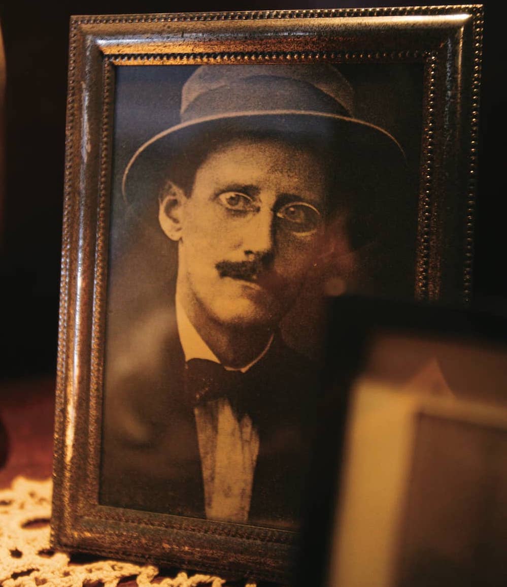 Sepia-toned framed photograph of James Joyce in a hat and bowtie, on display at the James Joyce Centre in Dublin.